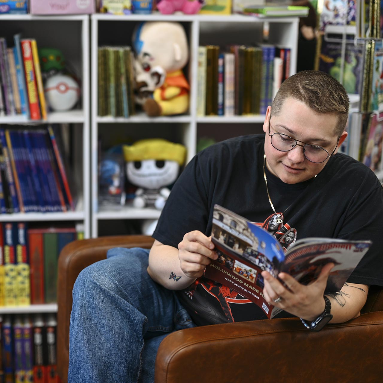 Person seated reading a book at a bookstore